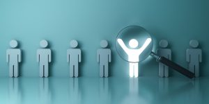 Searching for the right person concept, Stand out from the crowd and different concept , Magnifying glass focusing on the light man standing with arms wide open on green wall background. 3D rendering.