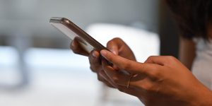 Close up woman's hand holding a smartphone and typing on the screen, for business, communication and technology concept.