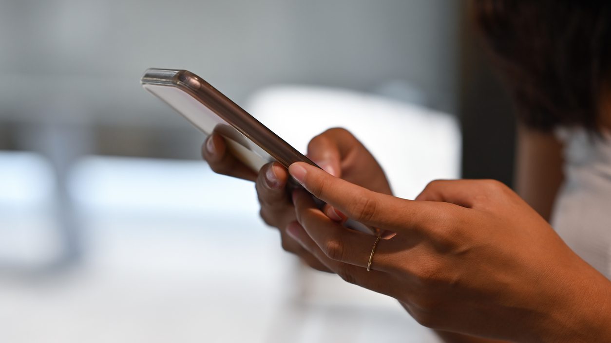 Close up woman's hand holding a smartphone and typing on the screen, for business, communication and technology concept.