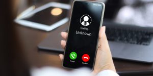 Unknown number displayed showing on smart mobile phone. Human use smartphone with incoming call from unknown number, spam, hacker, call center, crime,