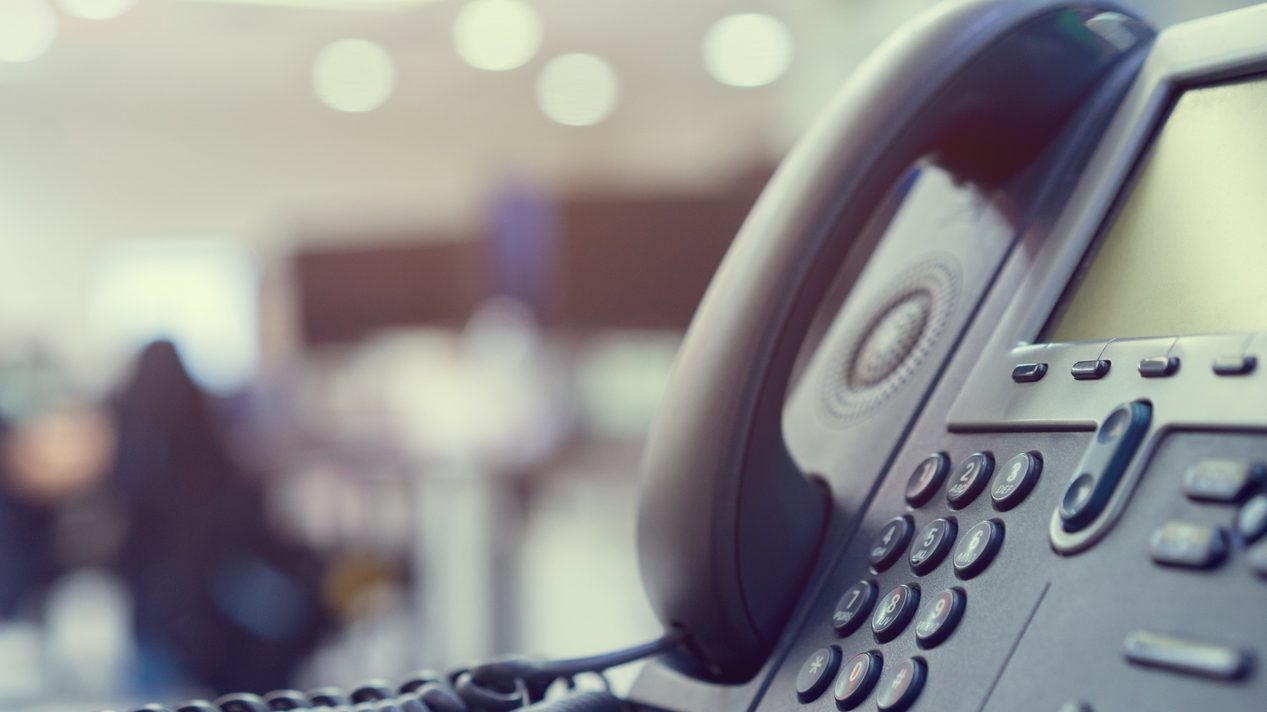 close up telephone VOIP technology standing on office desk in monitoring room for network operation center job concept