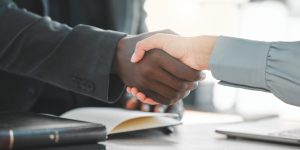 Business people, handshake and lawyers for introduction, agreement and greeting or recruitment. Partnership, closeup and integration or support in court case, network and thank you for hiring on desk