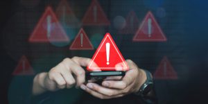 Emergency warning alert alarm on Smartphone, Data network protection, Virus alarm with people using computer.