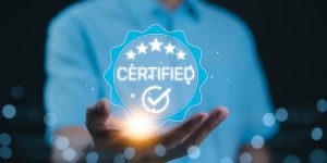 Certified concept. A person holds a glowing holographic badge displaying the word Certified with a checkmark and stars, symbolizing quality assurance, accreditation, and validation. ISO Certified,