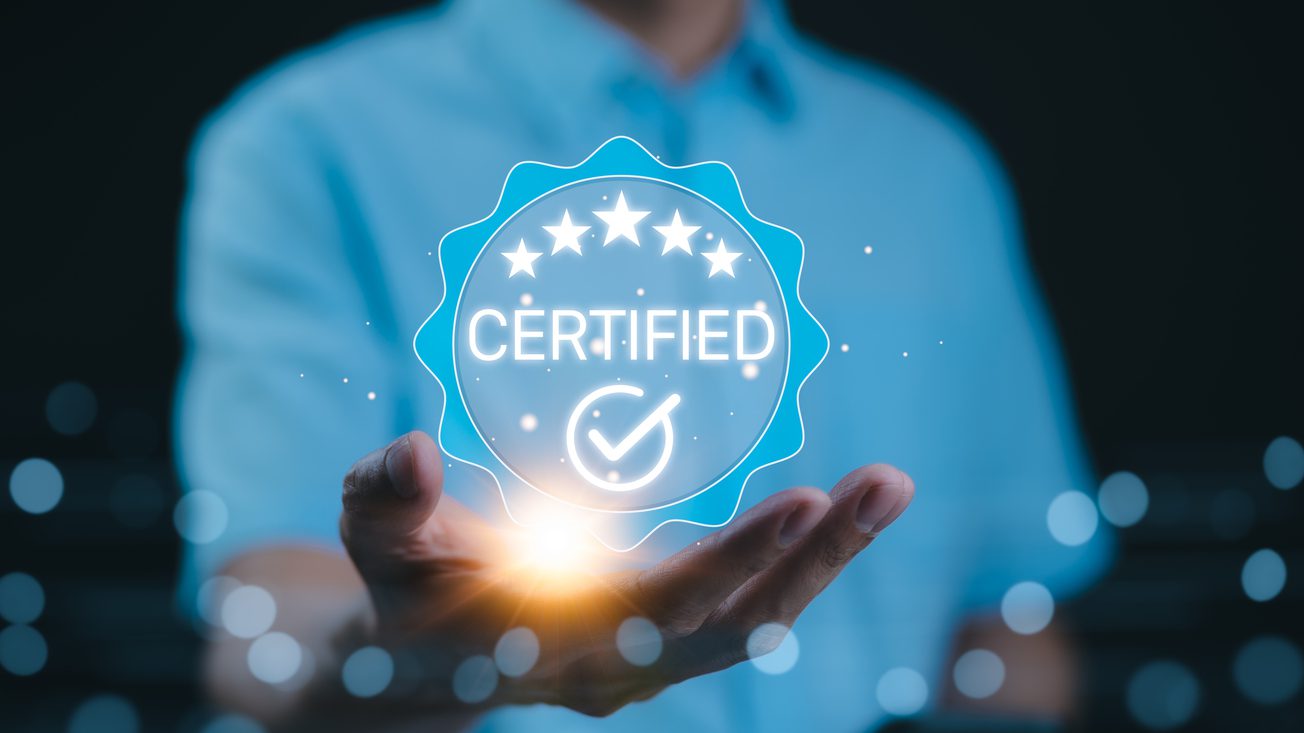 Certified concept. A person holds a glowing holographic badge displaying the word Certified with a checkmark and stars, symbolizing quality assurance, accreditation, and validation. ISO Certified,