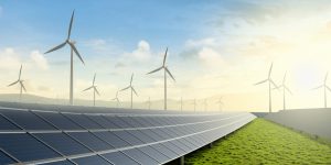 Solar farm and wind turbine on green fields with beautiful sunset