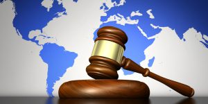 International law system, justice, human rights and global business concept with a gavel and world map on background 3D illustration.